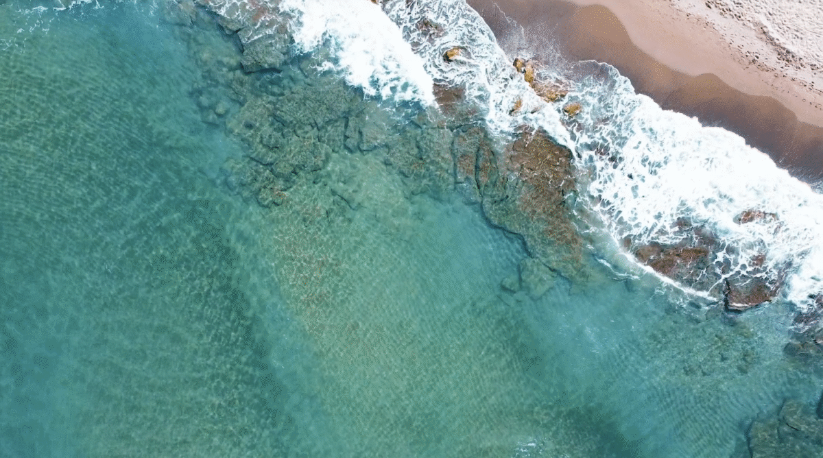 Aerial Flyover of an Aquamarine Beach