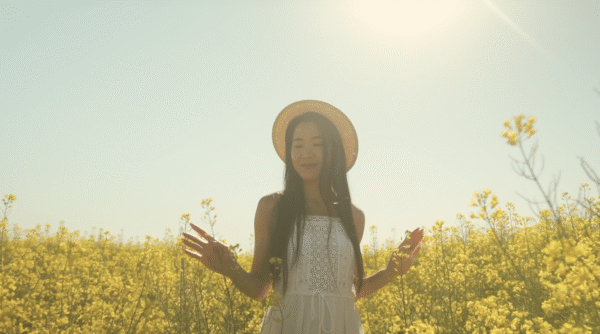 Young Woman Walking Through A Flower Field